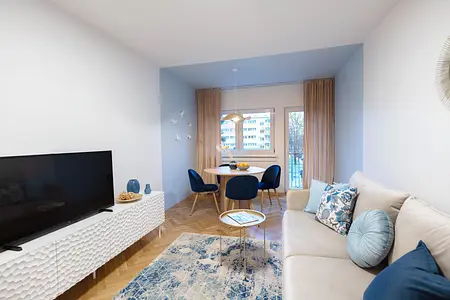 Wnętrze salonu z niebieskimi fotelami i białą sofą, nowoczesny design.