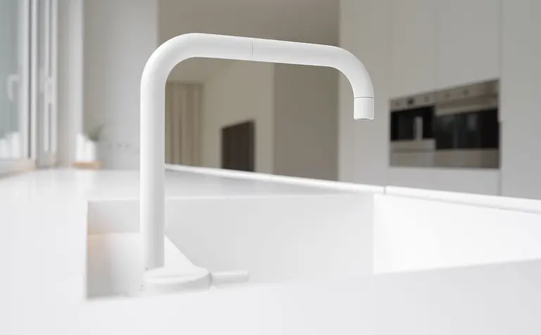 Minimalistyczna kuchnia z białym zlewem i kranem w stylu minimaluxe.