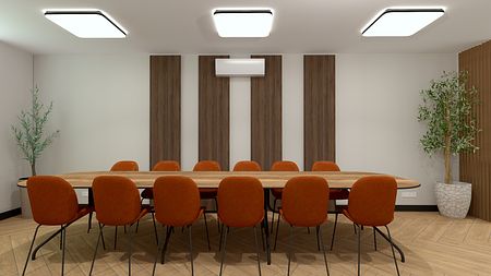 Wnętrze nowoczesnej sali konferencyjnej z drewnianym stołem i pomarańczowymi krzesłami.