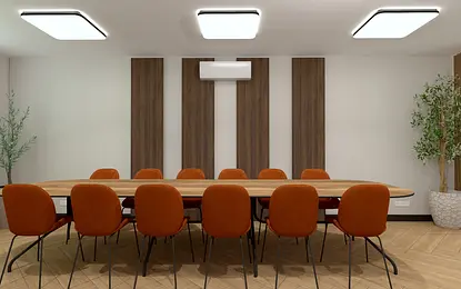 Wnętrze nowoczesnej sali konferencyjnej z drewnianym stołem i pomarańczowymi krzesłami.