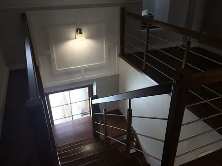 Widok korytarza z drewnianymi schodami, nowoczesny i tradycyjny design.