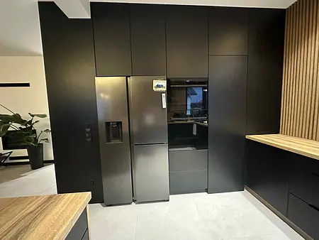 Nowoczesna kuchnia z czarnymi meblami i drewnianym akcentem. Styl industrialny.