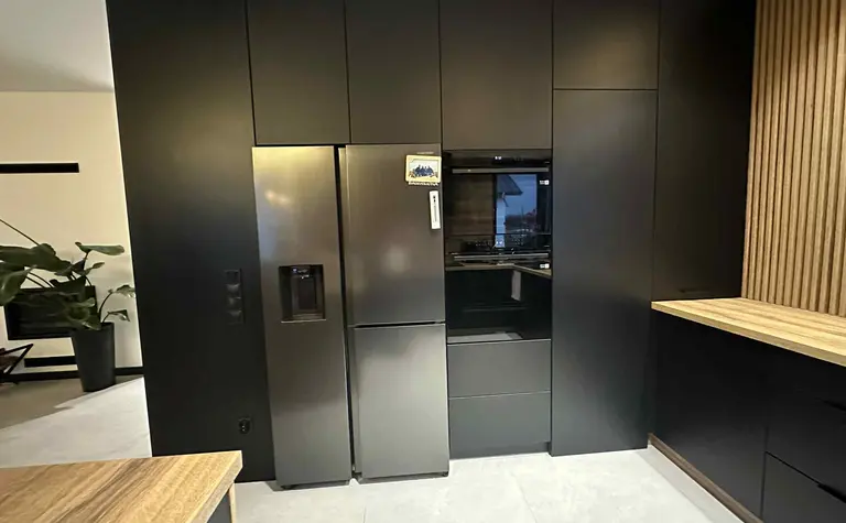 Nowoczesna kuchnia z czarnymi meblami i drewnianym akcentem. Styl industrialny.
