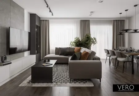 Wnętrze nowoczesnego salonu z minimalistycznym designem, szarymi meblami i zielonymi roślinami.