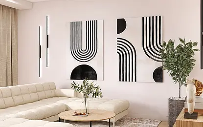 Nowoczesny salon z jasną sofą, obrazami i rośliną