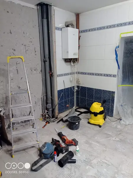 Wnętrze z białym piecem, niebieskimi płytkami i narzędziami remontowymi, styl glamour.