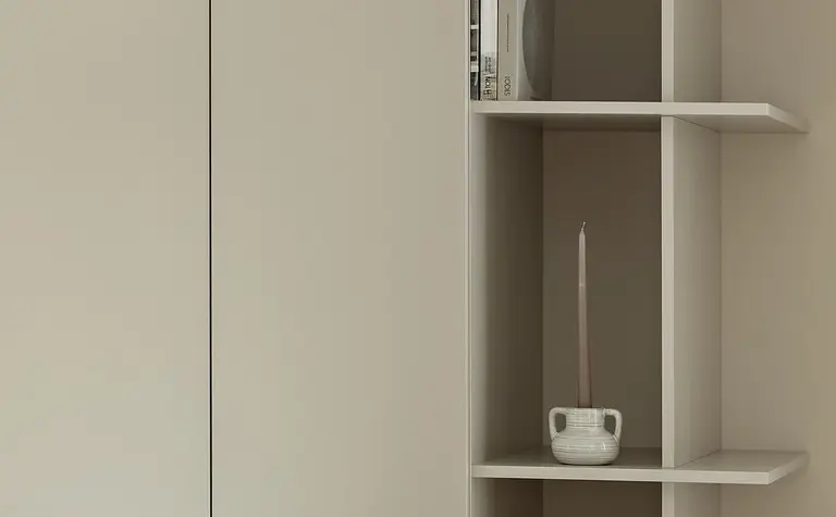 Współczesne wnętrze z jasnymi meblami i dekoracjami, w tym świecznikami.