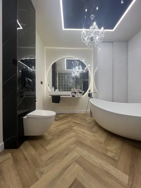 Wnętrze łazienki z wanną, czarnymi elementami i glamour