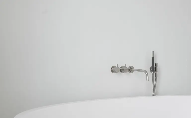 Nowoczesna łazienka z białą wanną i minimalistycznym designem.