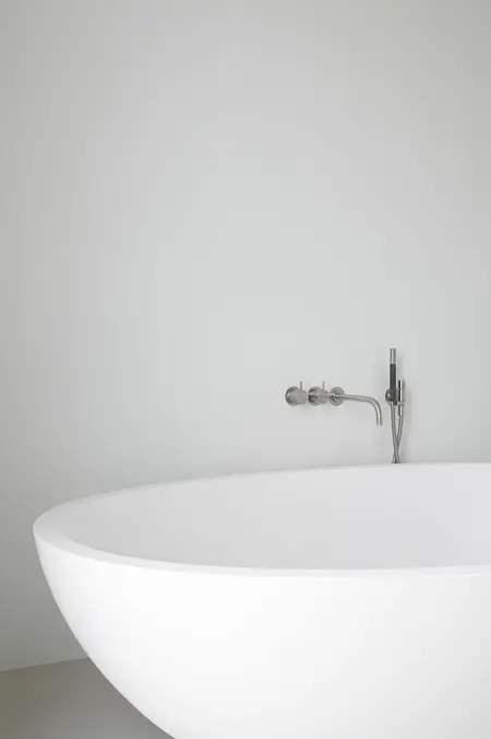 Nowoczesna łazienka z białą wanną i minimalistycznym designem.