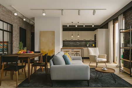 Wnętrze salonu z industrialnym i minimalistycznym stylem, szary dywan, drewniany stół.
