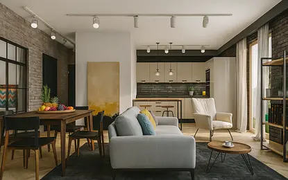 Wnętrze salonu z industrialnym i minimalistycznym stylem, szary dywan, drewniany stół.