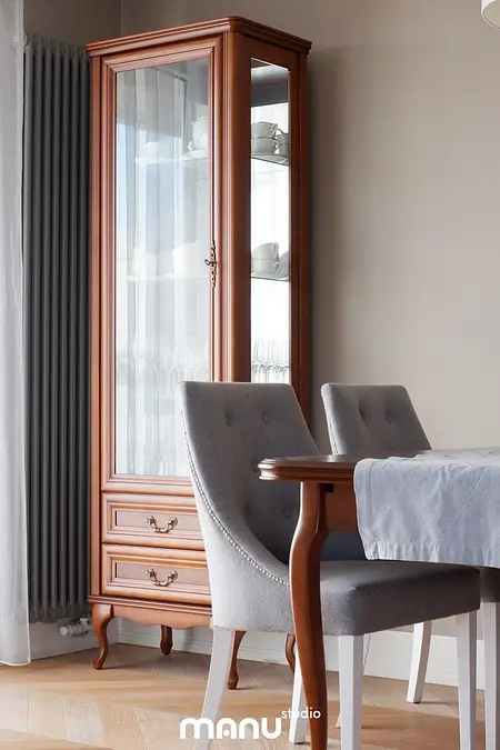 Jadalnia z tradycyjnym kredensem z drewna i szarymi krzesłami, eleganckie wykończenia.