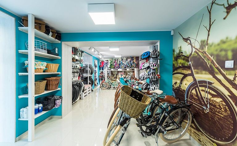 Garaż z rowerami, akcesoriami i niebieskimi ścianami w stylu boho.