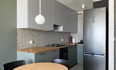 Kuchnia w stylu eklektycznym z minimalistycznymi akcentami i nowoczesnymi meblami.