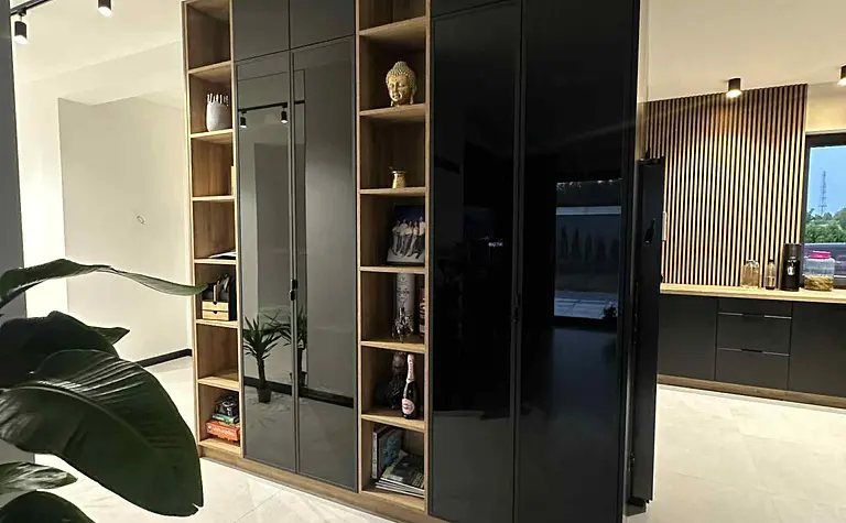 Wnętrze kuchni z czarnymi meblami i drewnianymi detalami w stylu industrialnym i nowoczesnym.