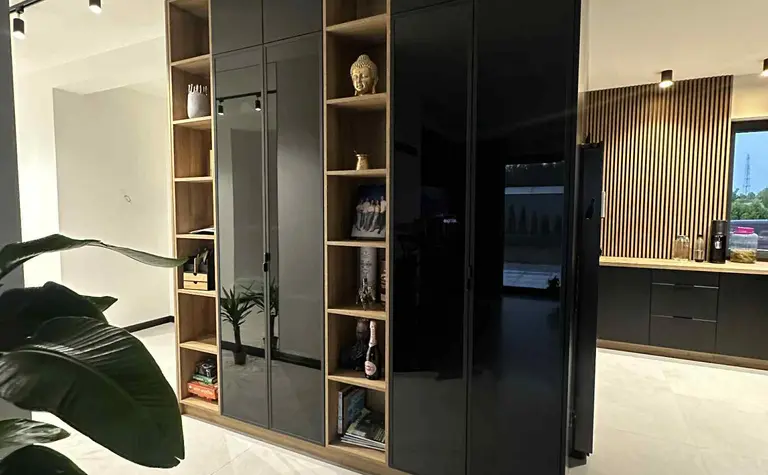 Wnętrze kuchni z czarnymi meblami i drewnianymi detalami w stylu industrialnym i nowoczesnym.