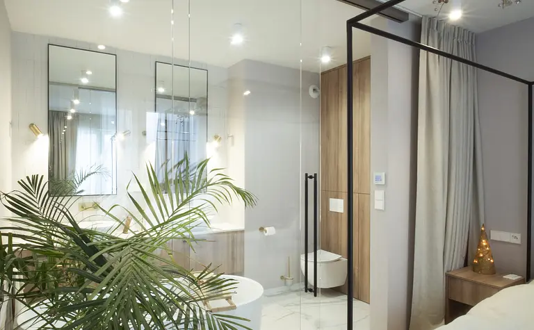 Wnętrze łazienki z białą wanną i drewnianymi detalami, styl quiet luxury.