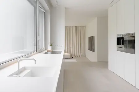 Wnętrze kuchni w stylu minimalistycznym z białymi meblami i nowoczesnym wyposażeniem
