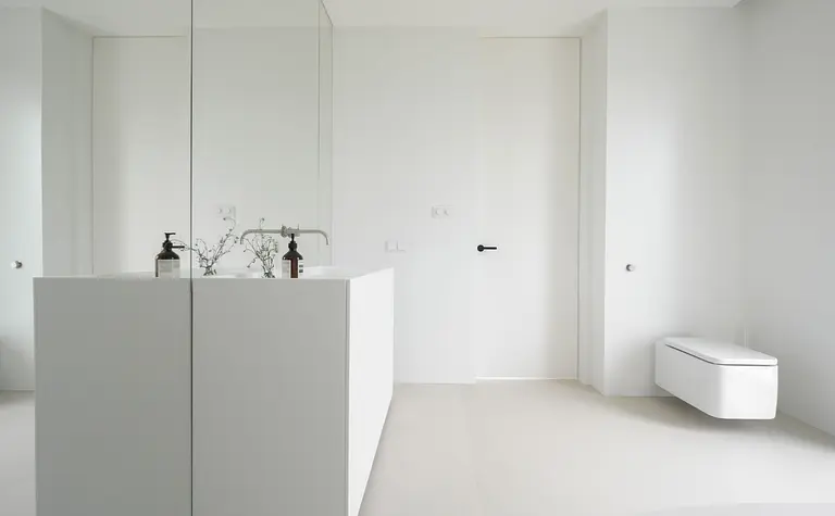 Nowoczesna łazienka z minimalistycznym designem, biała umywalka i lustro.