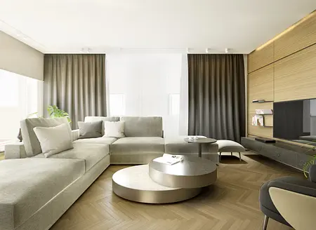 Przestronny salon z beżową narożną sofą, okrągłymi stolikami kawowymi, drewnianą podłogą w jodełkę, stylowymi zasłonami i minimalistycznymi półkami przy telewizorze