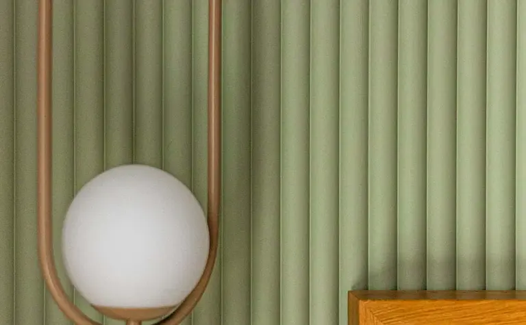 Wnętrze z lampą w nowoczesnym stylu soft minimalizm i zieloną ścianą.