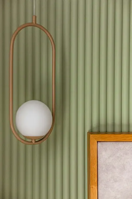 Wnętrze z lampą w nowoczesnym stylu soft minimalizm i zieloną ścianą.