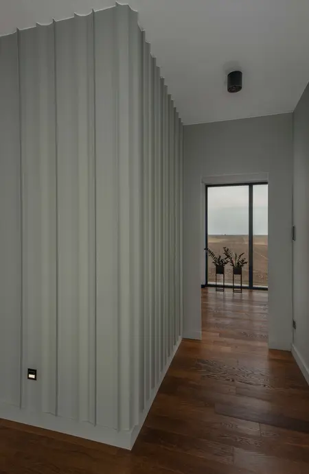 Korytarz w stylu minimalistycznym z zielonymi ścianami i drewnianą podłogą, nowoczesny design.