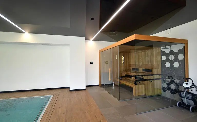 Wnętrze nowoczesnej sauny z drewnianymi elementami i minimalistycznym designem.
