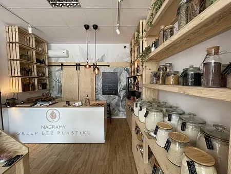 Wnętrze sklepu bez plastiku z drewnianymi półkami i słoikami na produkty sypkie, styl boho.