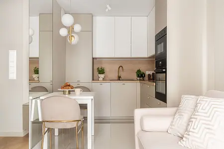 Wnętrze kuchni z beżowymi meblami i nowoczesnym oświetleniem.