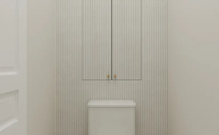 Toaleta w stylu art deco z białą ceramiką i mozaiką.