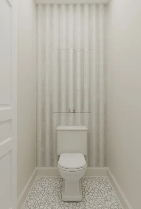 Toaleta w stylu art deco z białą ceramiką i mozaiką.