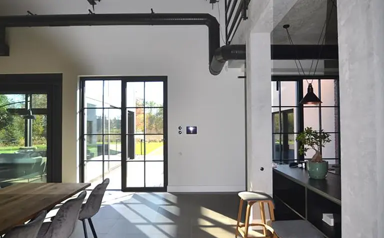 Wnętrze jadalni w stylu minimalistycznym z industrialnymi akcentami, nowoczesne meble.