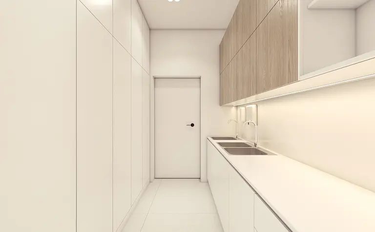 Kuchnia w stylu minimalistycznym z białymi meblami i drewnianymi detalami.