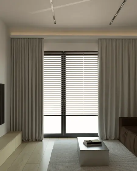 Minimalistyczny salon z szarymi zasłonami i nowoczesnym stolikiem.