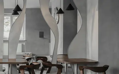 Wnętrze jadalni w stylu industrialnym i minimalistycznym z drewnianym stołem i szarymi ścianami.