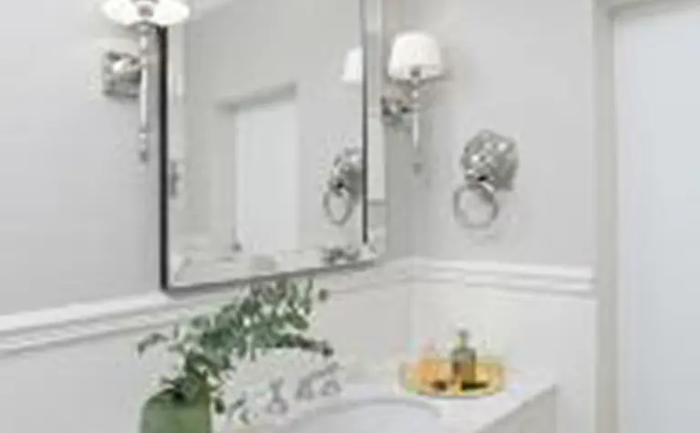 Wnętrze łazienki z białą umywalką, szarymi ścianami, style minimaluxe i quiet luxury.