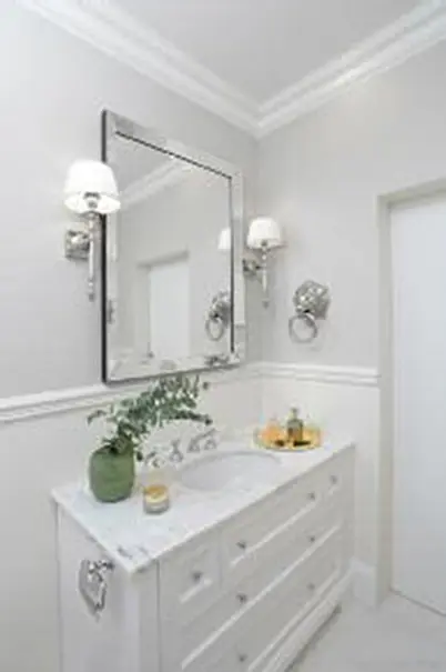 Wnętrze łazienki z białą umywalką, szarymi ścianami, style minimaluxe i quiet luxury.