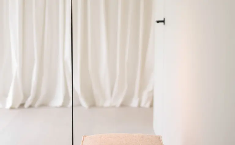 Minimalistyczne wnętrze z białymi zasłonami i lampą, idealne do nowoczesnych aranżacji.
