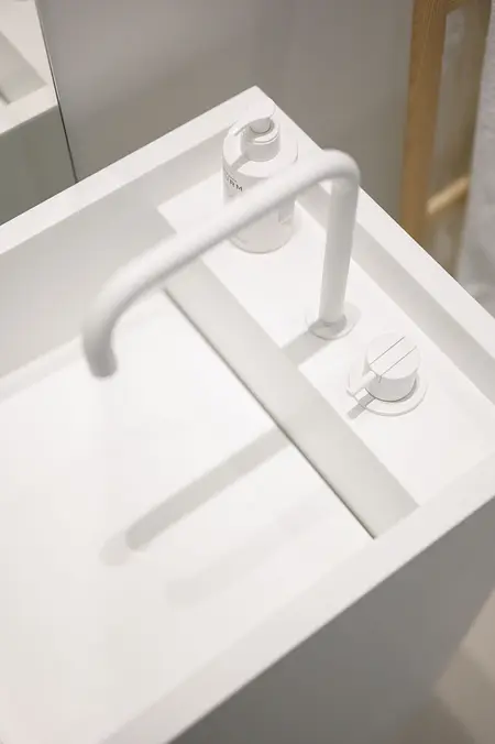 Minimalistyczna łazienka z białą umywalką i akcesoriami, styl minimaluxe.