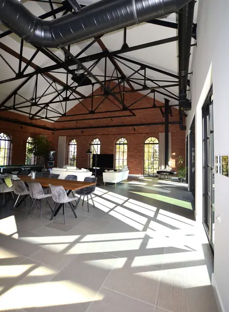 Wnętrze industrialne z minimalistycznymi meblami i dużymi oknami. Styl współczesny.