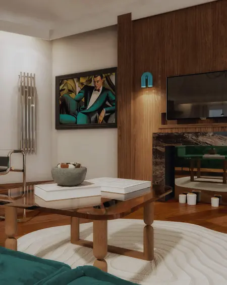 Wnętrze salonu w stylu art deco z zieloną sofą i drewnianymi detalami.