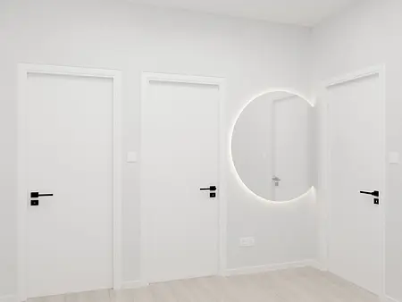 Minimalistyczny korytarz z białymi drzwiami i nowoczesnym lustrem.