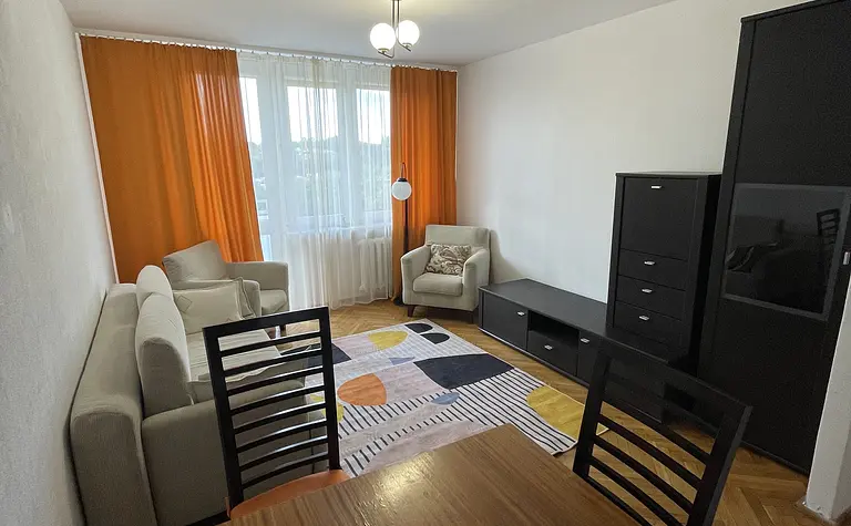 Wnętrze salonu z pomarańczowymi zasłonami i jasnymi meblami, nowoczesny styl.