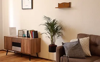 Wnętrze salonu w stylu tradycyjnym z brązową sofą i vintage meblami.