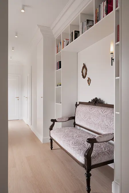 Eklektyczny przedpokój z vintage sofą i półkami na książki.