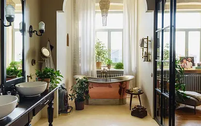Rustykalna łazienka z miedzianą wanną i roślinami, styl vintage i boho.