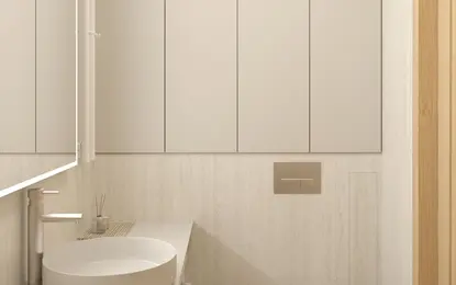 Wnętrze nowoczesnej łazienki z białą umywalką, minimalistycznymi meblami i jasnymi ścianami.