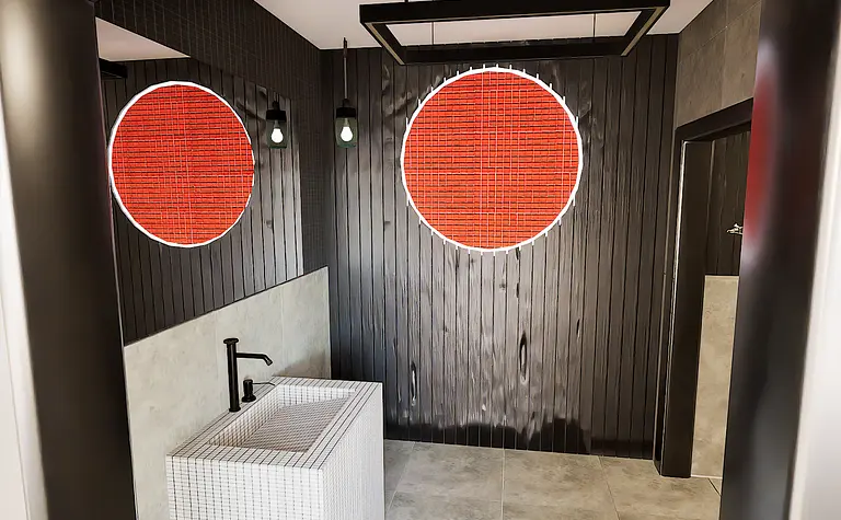 Nowoczesna łazienka z minimalistycznym designem, białą umywalką i czarnymi detalami.
